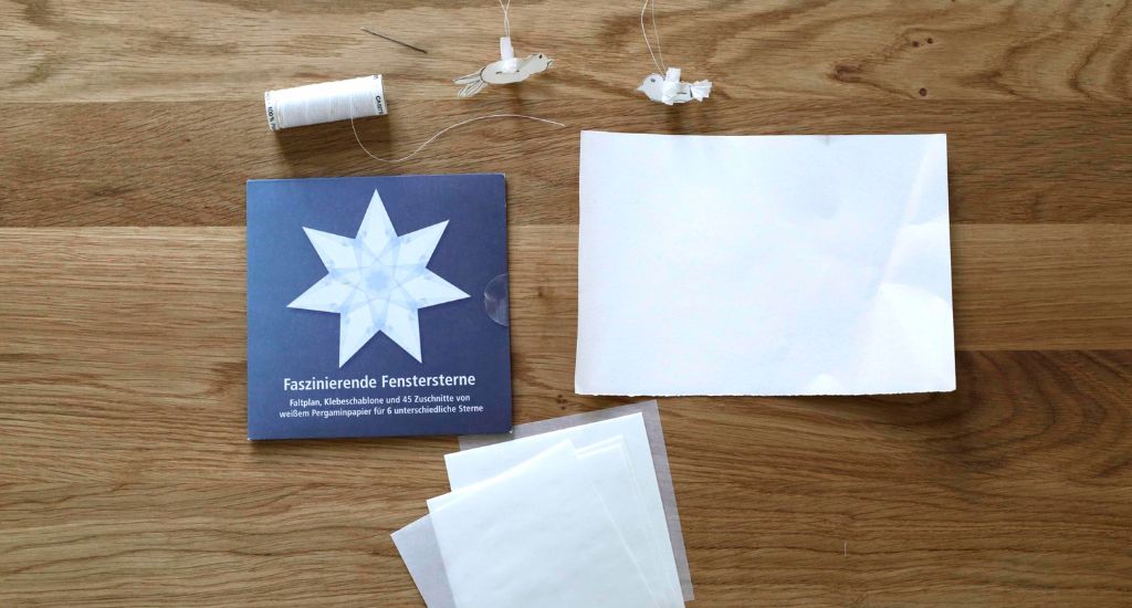 Materialien für das Basteln einer kleinen Taube aus Papier.