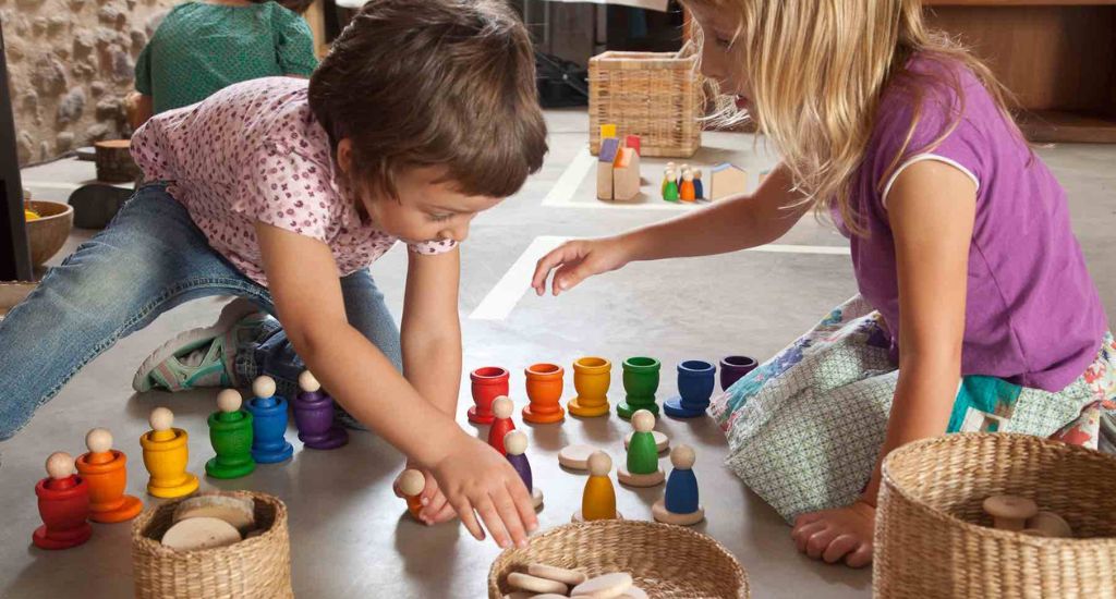 Kinder spielen mit buntem Holzspielzeug mit dem Spiel Gut Siegel.